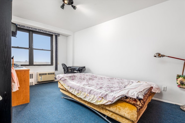 bedroom with radiator heating unit, dark carpet, and a wall mounted air conditioner