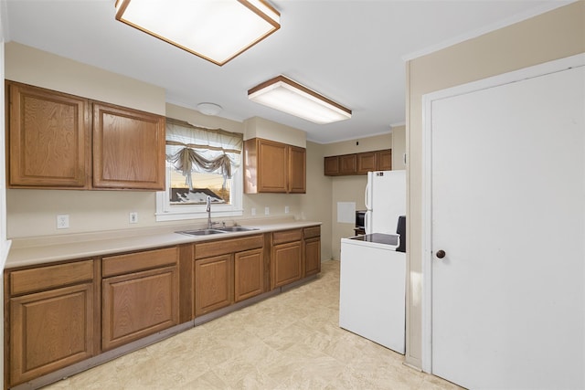 kitchen featuring white refrigerator, sink, and washer / clothes dryer