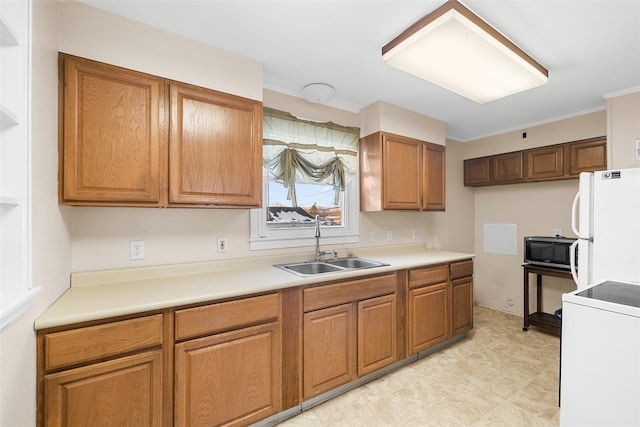 kitchen featuring sink, ornamental molding, range, and white fridge