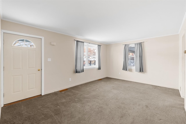 entrance foyer featuring crown molding and carpet