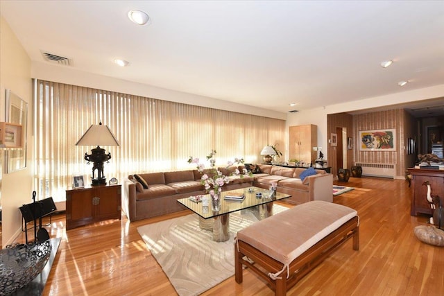 living room featuring radiator heating unit and light hardwood / wood-style floors