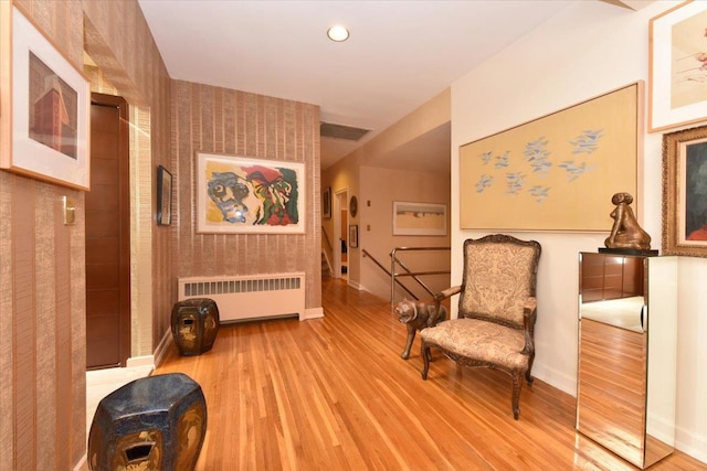 sitting room with radiator heating unit and light hardwood / wood-style flooring