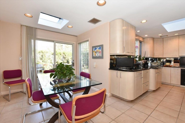 kitchen with backsplash, a skylight, and light tile patterned floors