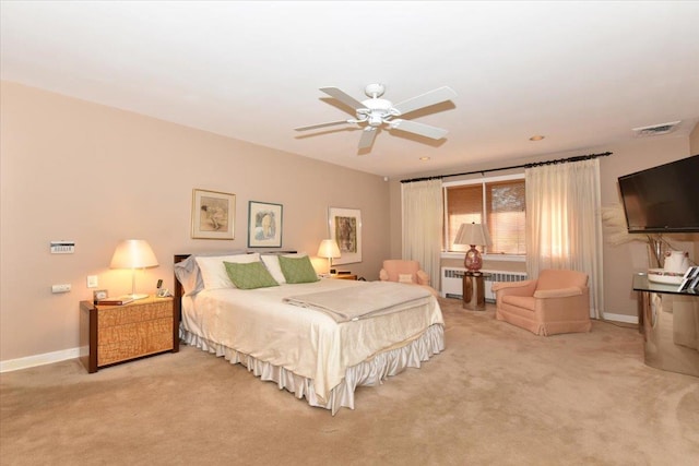 carpeted bedroom with radiator heating unit and ceiling fan