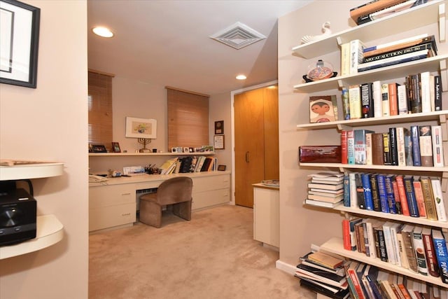 carpeted home office featuring built in desk