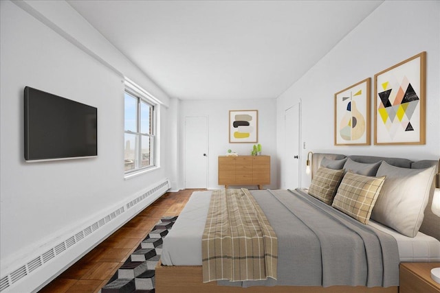 bedroom with hardwood / wood-style flooring and a baseboard heating unit