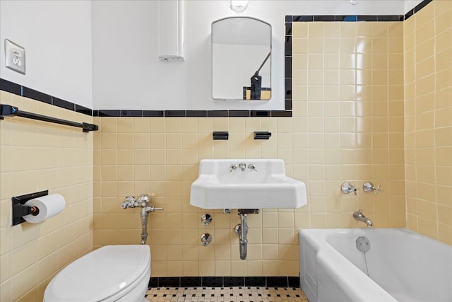 bathroom with tile patterned floors, sink, a washtub, toilet, and tile walls