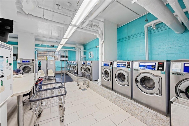 laundry room with washer and dryer and light tile patterned floors