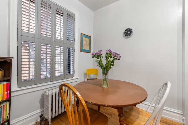 dining room with radiator heating unit and hardwood / wood-style floors