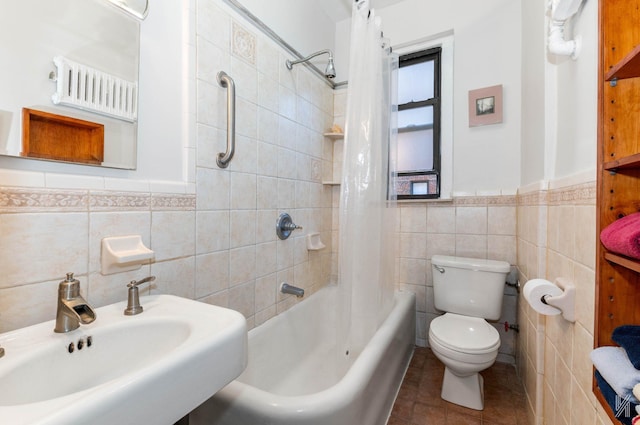 full bathroom featuring toilet, shower / bath combo with shower curtain, sink, and tile walls