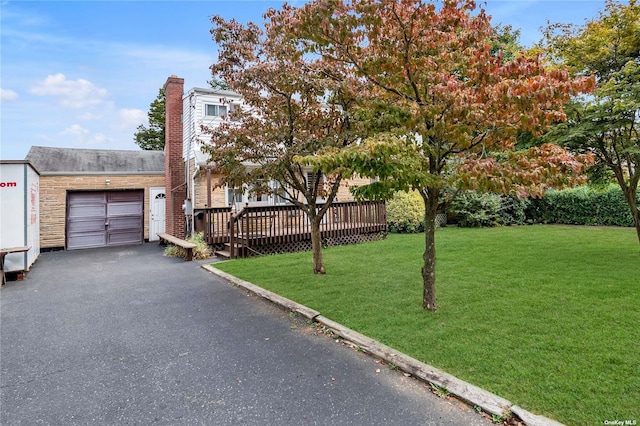 view of front of property with a garage, a deck, and a front yard