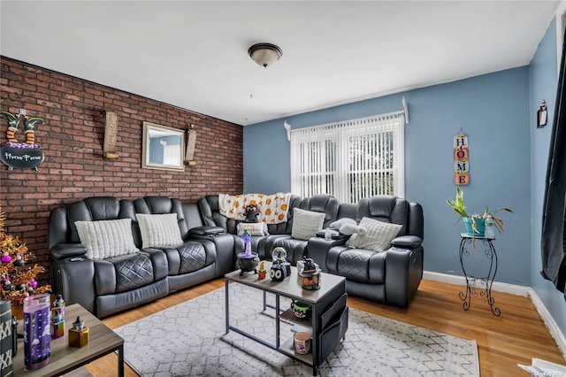 living room with light hardwood / wood-style floors and brick wall