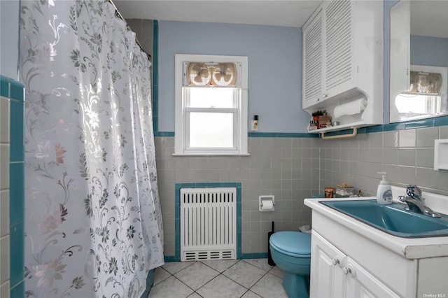 bathroom featuring walk in shower, vanity, tile walls, tile patterned flooring, and radiator heating unit