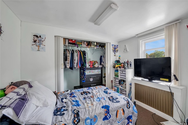 carpeted bedroom featuring a closet and lofted ceiling