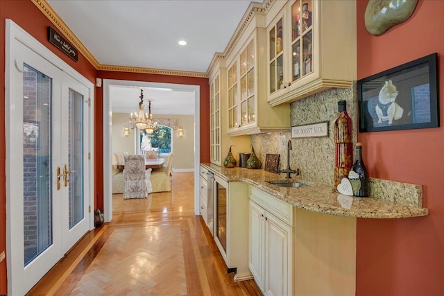 bar with sink, cream cabinets, and french doors