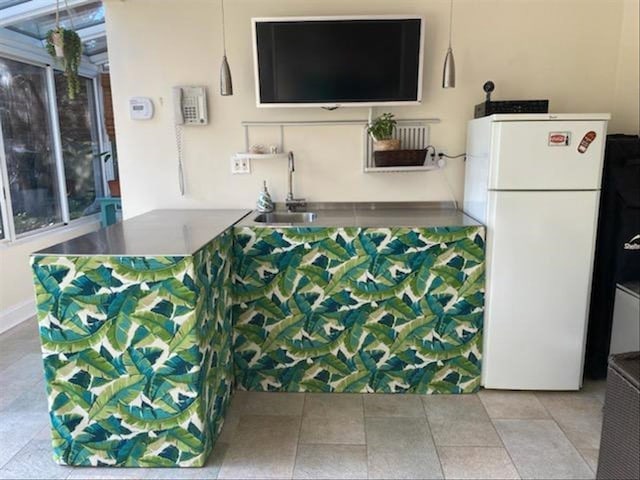 kitchen featuring white refrigerator, sink, and kitchen peninsula