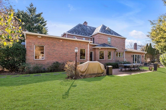 rear view of property with a patio and a lawn