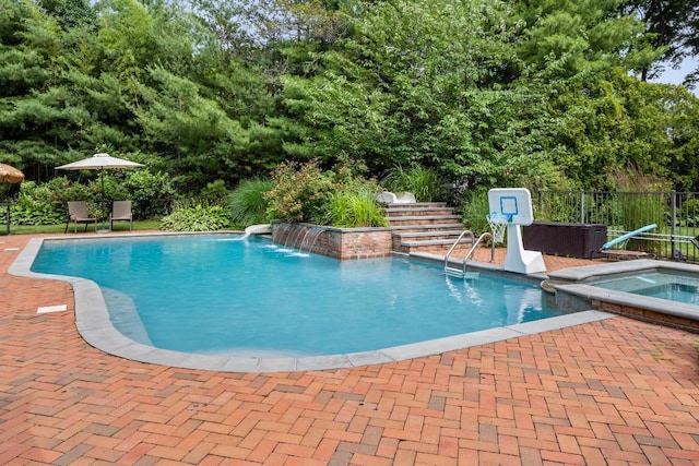 view of pool with a patio area, pool water feature, and an in ground hot tub