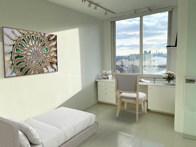 tiled office featuring expansive windows, built in desk, and track lighting