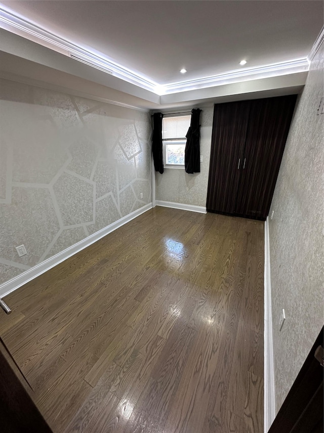 spare room with hardwood / wood-style flooring and crown molding