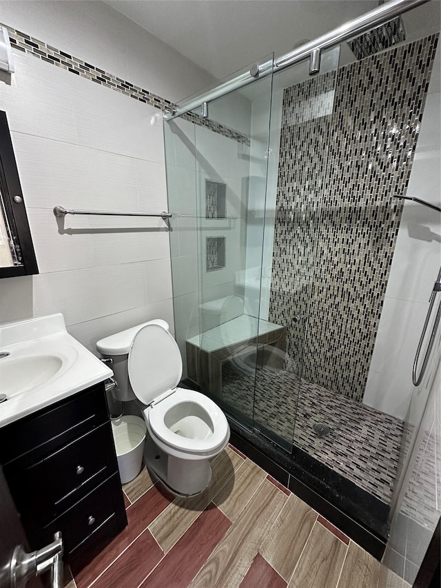 bathroom with toilet, vanity, and walk in shower