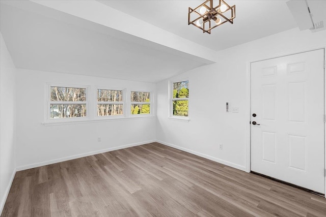 foyer with lofted ceiling, a notable chandelier, and light hardwood / wood-style flooring