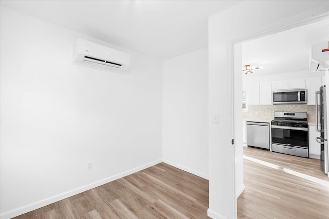 interior space featuring a wall mounted AC and light hardwood / wood-style flooring