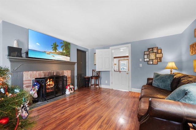 living room featuring hardwood / wood-style flooring and a brick fireplace