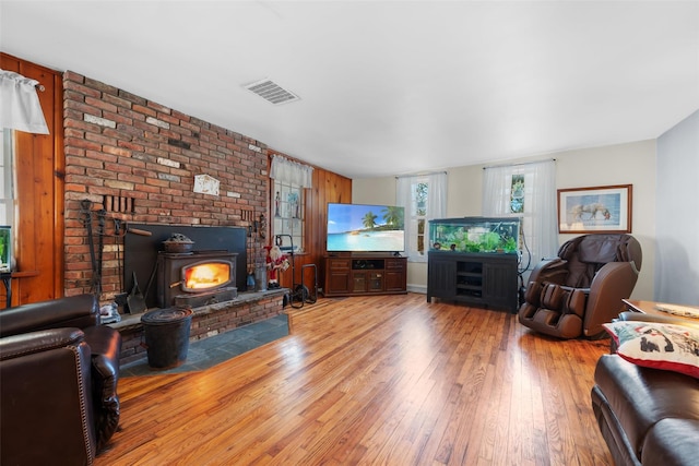 living room with hardwood / wood-style flooring and a wood stove