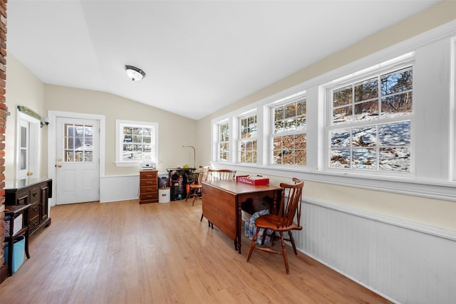 office featuring wood walls, lofted ceiling, and light wood-type flooring