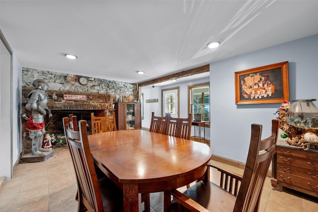 tiled dining space with a fireplace