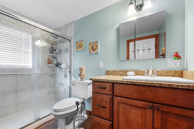 bathroom with an enclosed shower, vanity, toilet, and tile patterned flooring