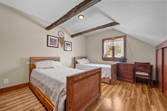 bedroom with lofted ceiling with beams and light hardwood / wood-style flooring