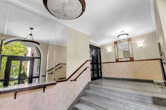 staircase with crown molding and tile walls