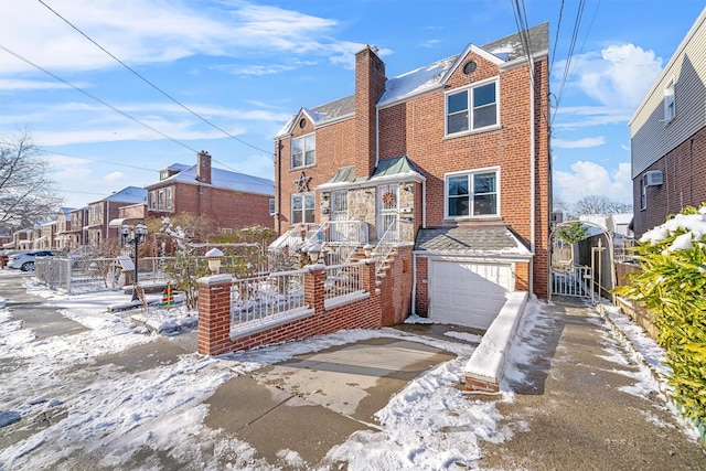 snow covered property with a garage