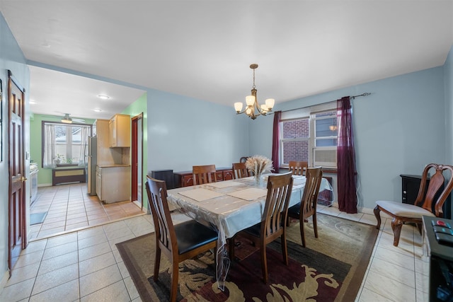 tiled dining space featuring ceiling fan with notable chandelier