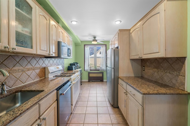 kitchen featuring light stone counters, light tile patterned floors, backsplash, and appliances with stainless steel finishes