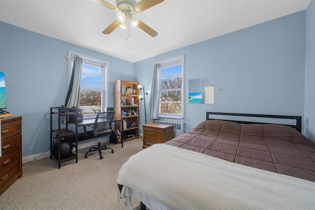 bedroom with light carpet, radiator heating unit, and ceiling fan