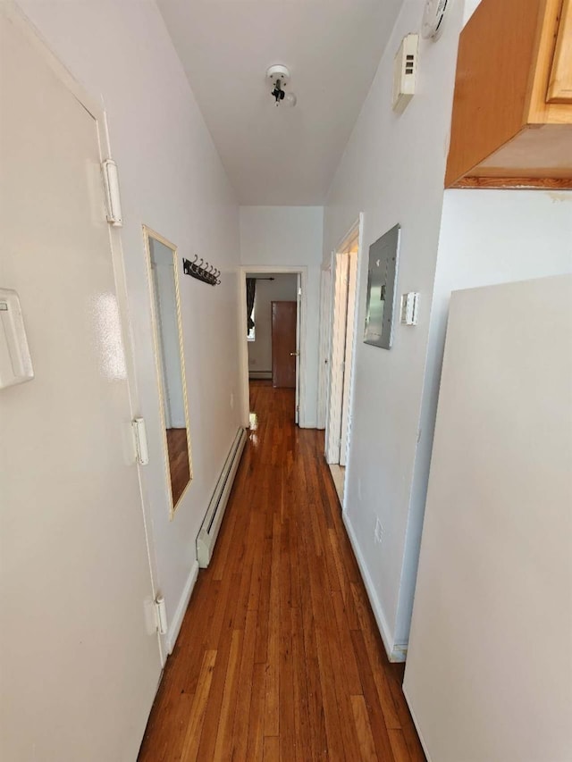 corridor featuring dark hardwood / wood-style floors, baseboard heating, and electric panel