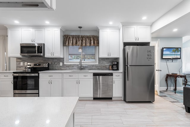 kitchen with pendant lighting, white cabinets, stainless steel appliances, and sink