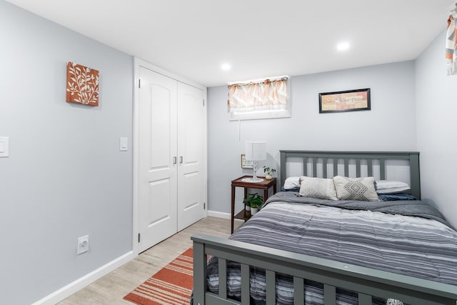 bedroom with light hardwood / wood-style floors and a closet