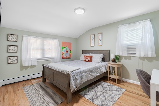 bedroom featuring a baseboard radiator, vaulted ceiling, and light wood-type flooring