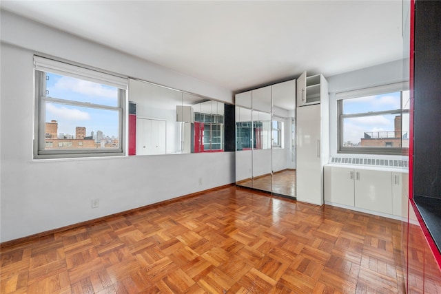 empty room featuring radiator and parquet flooring