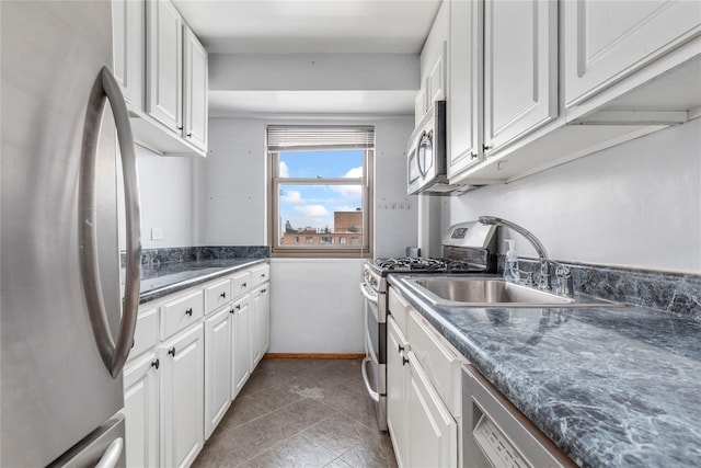 kitchen featuring stainless steel appliances, sink, dark stone counters, and white cabinets