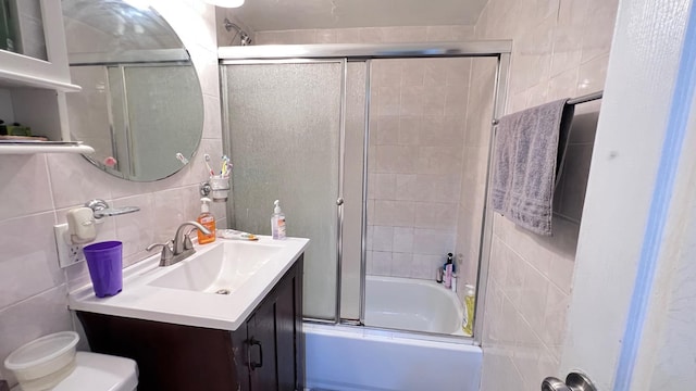 full bathroom with enclosed tub / shower combo, backsplash, toilet, vanity, and tile walls