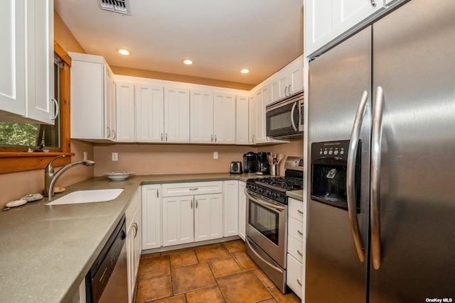 kitchen with appliances with stainless steel finishes, white cabinetry, and sink