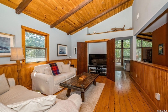 living room featuring wooden ceiling, light hardwood / wood-style floors, wooden walls, and lofted ceiling with beams