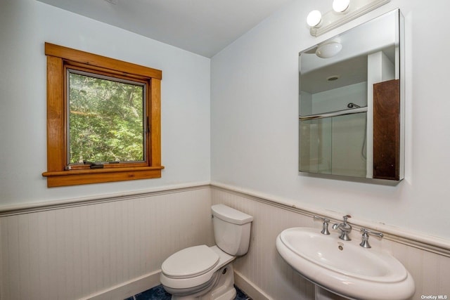 bathroom with toilet, an enclosed shower, and sink