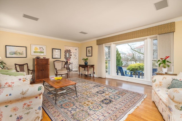 living room featuring crown molding and light hardwood / wood-style flooring