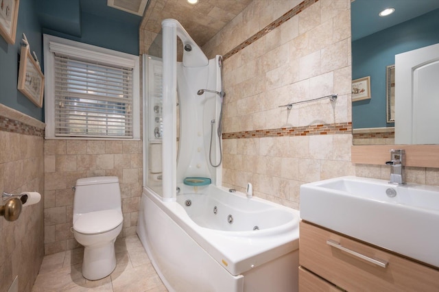 full bathroom featuring tile patterned flooring, shower / bath combination, toilet, vanity, and tile walls